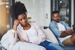 © peopleimages.com - Ignore, woman and couple with fight on sofa for cheating, betrayal or affair with conflict or breakup in home. Black people, frustrated or toxic marriage in living room with disagreement and argument