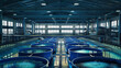 © VK Studio - An expansive indoor fish farming facility with neatly aligned blue tanks, under a high ceiling with fluorescent lighting, showcasing modern aquaculture practices.