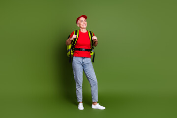 Poster - Full body photo of mature woman delivery employee thermo bag look empty space wear red uniform workwear isolated on khaki color background