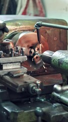 Wall Mural - A worker controls the process of drilling a hole in a part on a lathe using coolant for cleanliness processing of surface. Close-up.