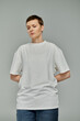© LIGHTFIELD STUDIOS - A woman with short hair wearing a white t-shirt and jeans stands against a gray background