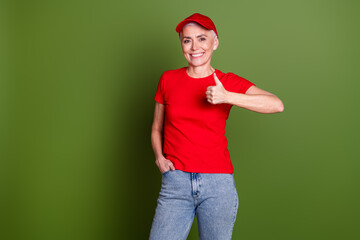 Sticker - Photo of lovely pensioner lady delivery service employee thumb up approve dressed red uniform workwear isolated on khaki color background