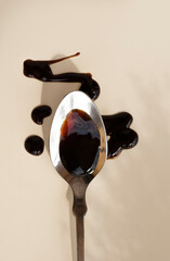 Balsamic vinegar from Modena on a spoon. An important ingredient in the sauce of Italian cuisine. Balsamic notes in perfumery, balsamic mood.  Warm sunlight, eco simple style. Earth tones 
