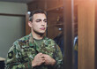 © Penn/peopleimages.com - Man, army and soldier in home, uniform and duty for pride, respect and country in ready for deployment. Male person, war and hero in barracks with service, camouflage and mirror as recruit or patriot