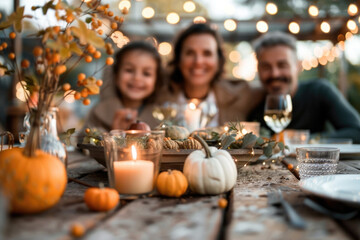 Family having a meal outdoors, table setting with pumpkins and autumn decoration