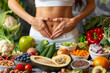 © BetterPhoto - A healthy assortment of fruits and vegetables surrounding a woman forming a heart shape on her stomach, symbolizing nutrition and gut health.