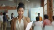 © seelya - Confident African American Businesswoman Holding Documents in a Modern Office