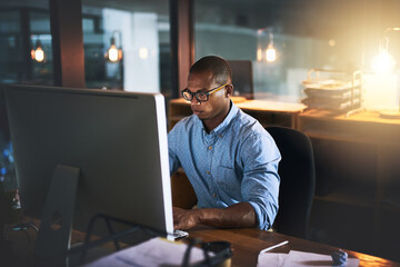 Leinwandbilder - Office, computer and business black man with glasses for website, research and reading news at night. Corporate, developer and worker online for software update, networking and working on web design