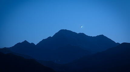 Wall Mural - A mountain range is silhouetted against a dark sky with a few stars visible