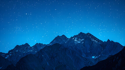 Wall Mural - A mountain range is silhouetted against a dark sky with a few stars visible