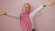© Krakenimages.com - Happy woman with hijab embracing life against pink background