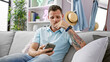 © Krakenimages.com - Handsome hispanic male with tattoos thinking while holding smartphone in a modern living room