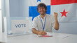 © Krakenimages.com - Young man voting in an election with the panamanian flag in the background, showing success and happiness.