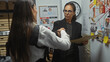 © Krakenimages.com - Two women investigators discuss a case in a busy police department office, amidst evidence and crime investigation photos.