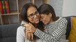 © Krakenimages.com - A mother and daughter embracing lovingly in a cozy living room, reflecting a warm family bond.