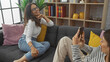 © Krakenimages.com - A smiling woman poses while her daughter takes a photo with a smartphone in a cozy home interior.