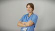© Krakenimages.com - Confident caucasian female nurse with crossed arms, smiling in blue scrubs against a white background