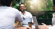 © peopleimages.com - Laptop, group and business people in outdoor coffee shop with collaboration, b2b negotiation and partnership meeting. Employees, computer and handshake in cafe for agreement, thank you and success
