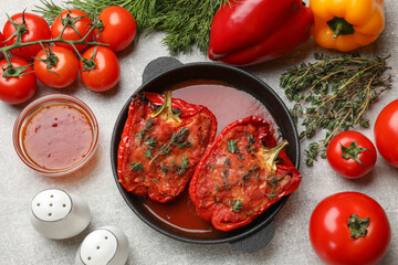 Wall Mural - Tasty stuffed peppers in dish and ingredients on light grey table, flat lay