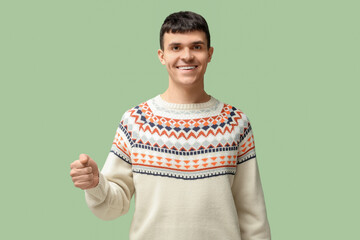 Wall Mural - Young deaf mute man using sign language on green background