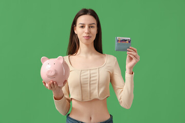 Sticker - beautiful young woman with credit card holder and piggy bank on green background