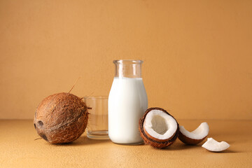 Wall Mural - Bottle of tasty fresh coconut milk on beige background