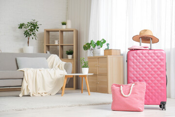 Wall Mural - Packed suitcase with hat, beach bag and flip-flops in interior of living room