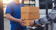 © Phanphen - Asian delivery express courier young man use giving boxes to woman customer he wearing protective face mask at front home
