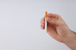 © Atlas - A cigarette in a man's hand on a light background