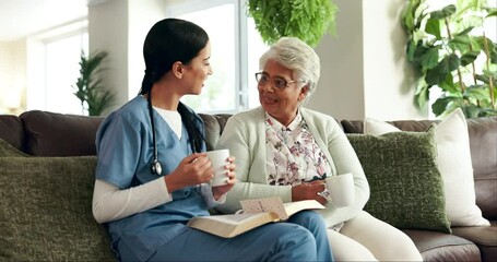 Sticker - Sofa, senior woman and caregiver with book for reading, listening and discussion with tea cup at home. Couch, elderly person and female nurse for bible session, guidance and wisdom in retirement