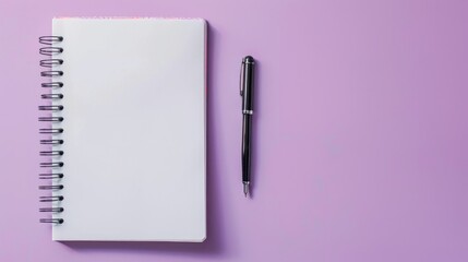 Notebook open with pen on purple surface