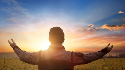 Wall Mural - silhouette of a man with hands raised in the sunset concept for religion