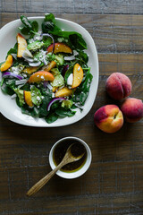 Sticker - Fresh peach salad with avocado and spinach on a rustic table