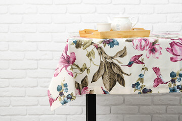 Wall Mural - Floral Tablecloth On Table With Teapot And Cup