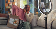 © peopleimages.com - Fashion, unboxing and woman on sofa for live stream, content creation or online shopping in living room. Home, influencer and Indian girl on couch with mobile, ring light and package on social media