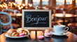© CreativeMania - Cozy cafe in Paris city with traditional French macarons and chalkboard with word Bonjour. Travel to France, welcome to Paris, French patisserie and food