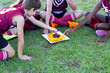 © Austockphoto - children in sports uniform sitting on ground and having fruit off a plate on the grass