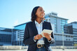 © Meeko Media - Confident Businesswoman Using Tablet in Urban Setting, Smiling and Looking Forward