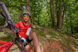 © Sergey Novikov - Young cyclist pauses for drink in a peaceful, green woodland