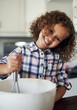 © CanBorg/peopleimages.com - Kitchen, portrait and girl with mixing for baking, recipe and ingredients for child development with learning. Home, counter and kid with dessert, pastry and breakfast preparation in bowl as baker