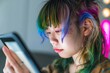 © alisaaa - Young Gen-Z Female Using A Tablet At Home Close up head shot of young asian Gen-Z female with colorful hair creating digital art at home on her tablet.