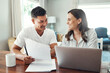 © peopleimages.com - Financial, laptop and couple with paperwork in dining room for bills, life insurance or loan approval. Happy, document and hispanic man with woman for planning budget, payment or investment in home