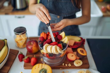 Woman preparing healthy breakfast in kitchen Woman in kitchen making a healthy fruit cup for breakfast