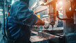 © VK Studio - A skilled worker operates a high-precision industrial machine, focusing intently as the ambient light highlights the metal surfaces and tools around him.