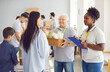 © Studio Romantic - Volunteers at a humanitarian aid center handing a food box to a refugee family. This act of charity and community service exemplifies the center dedication to providing help and support.