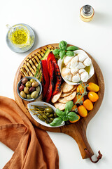 Wall Mural - Board with ITALIAN summer foods and grilled vegetables: mozzarella braid, cherry tomatoes, grilled eggplant and zucchini, olives and capers