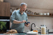 © ReeldealHD images - Mature retired male checking recipe online whilst he prepares a homemade meal