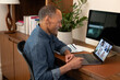 © ReeldealHD images - Mature man working from home on a videocall using a laptop in a home office