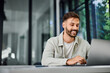 © bnenin - A smiling man, working over the laptop, at the office.
