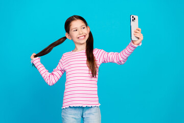 Sticker - Photo of cute small girl with ponytails dressed striped shirt make selfie on smartphone hold tail isolated on blue color background